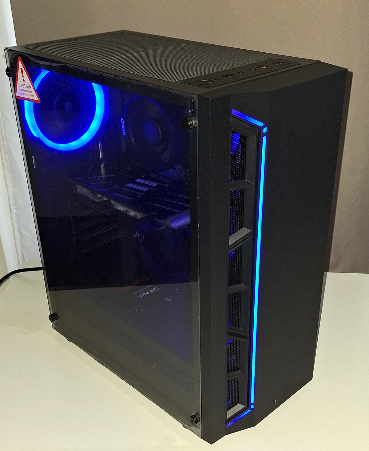 Gaming PC mit Seitenteil aus Glas und blauer RGB-Beleuchtung.